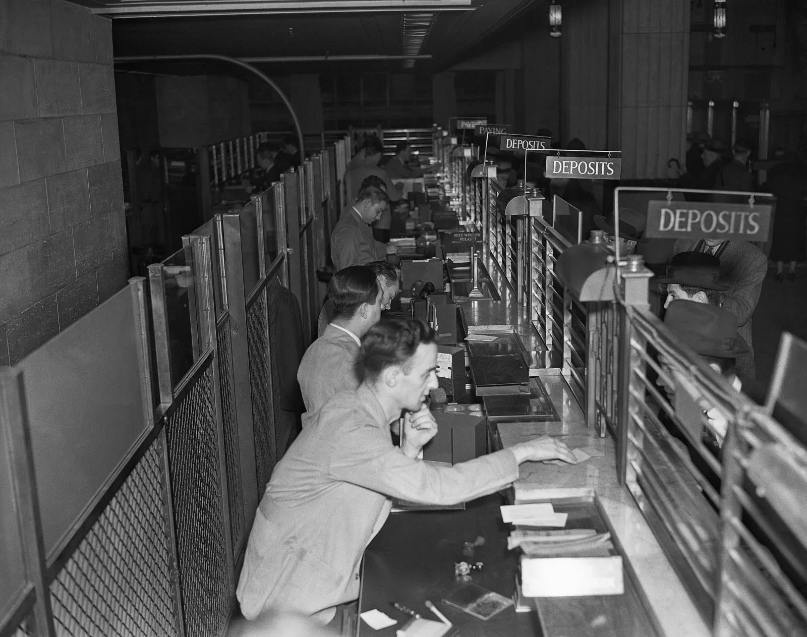 Customers line up at a bank tellers' cage on December 16, 1936, in New York.