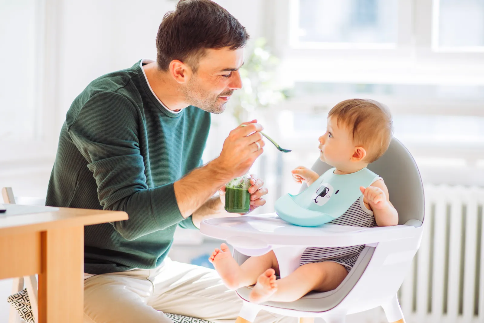 A man feeding a baby.