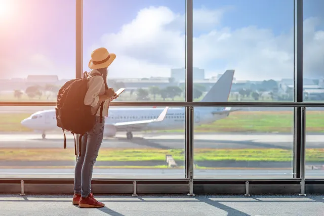 Passenger standing near airport departure gate.