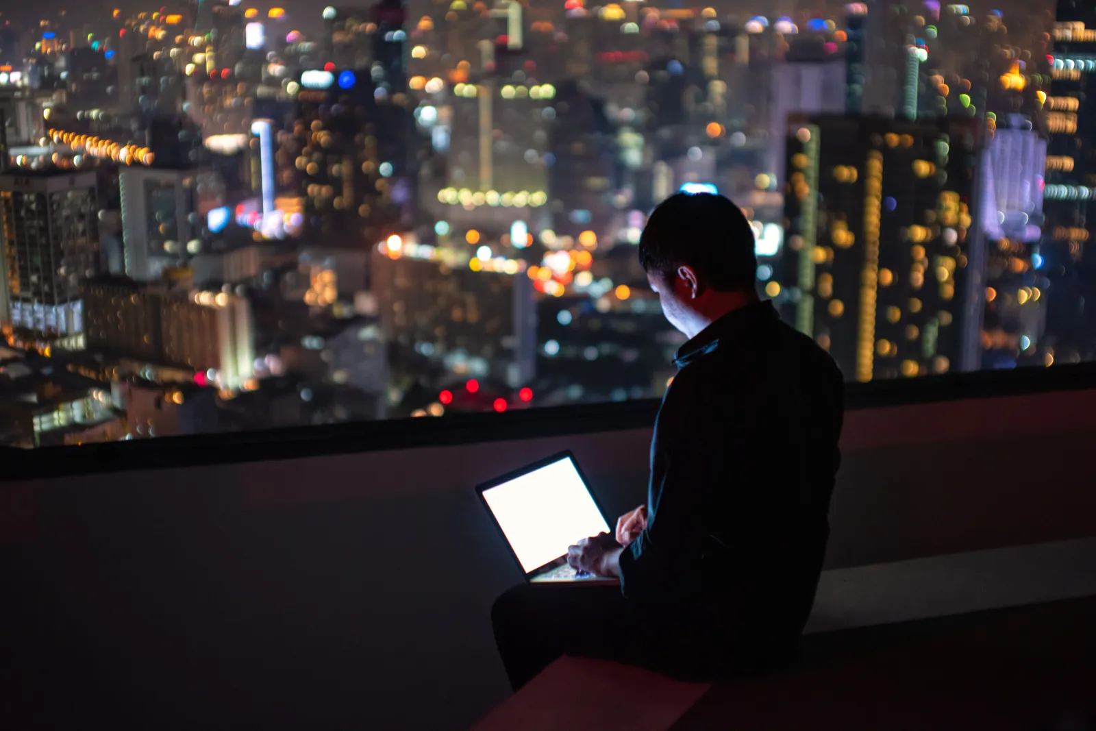 Man Uses Notebook on Rooftop