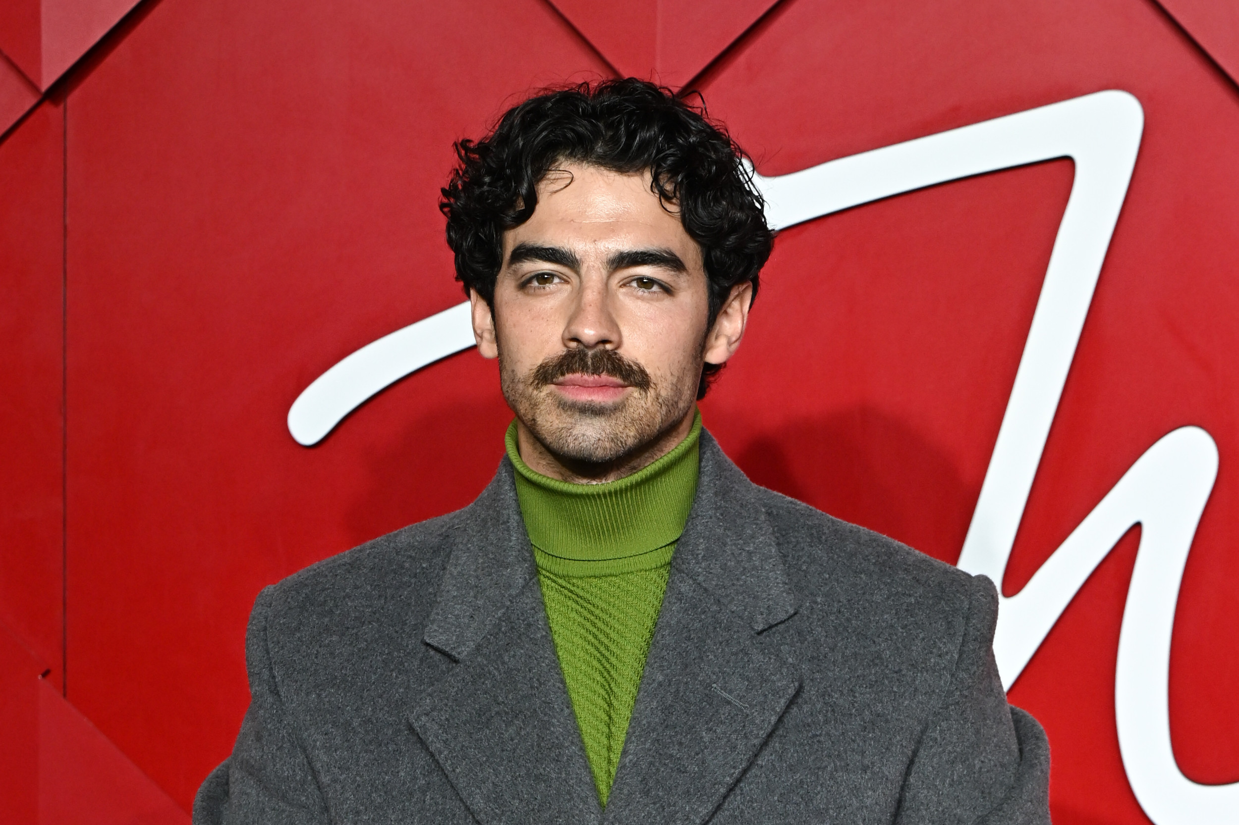 red dress joe jonas Joe Jonas' 1970s Mustache Makes Red Carpet Debut at British Fashion Awards