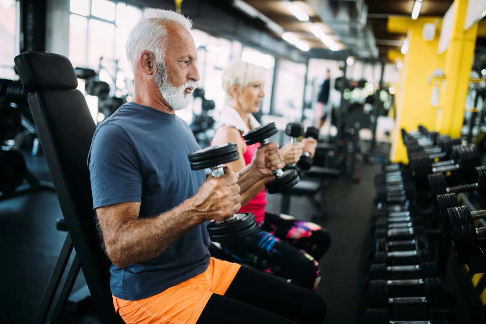 Elderly couple doing weight exercises.