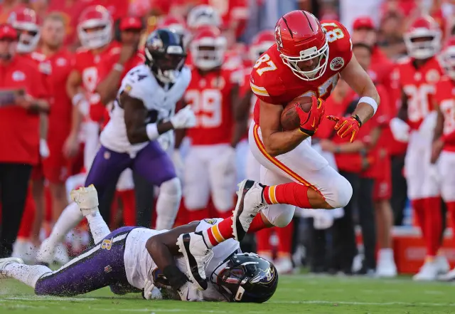 Baltimore Ravens defenders attempting to tackle Chiefs star Travis Kelce