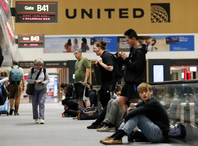 Passengers crowd in the departure lounge of Denver International Airport in 2024 due to flight delays.
