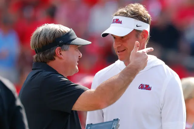 Head coach Lane Kiffin of the Mississippi Rebels speaks with head coach Kirby Smart of the Georgia Bulldogs