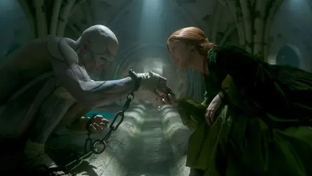 Frankenstein's monster touches hands with a red-haired woman