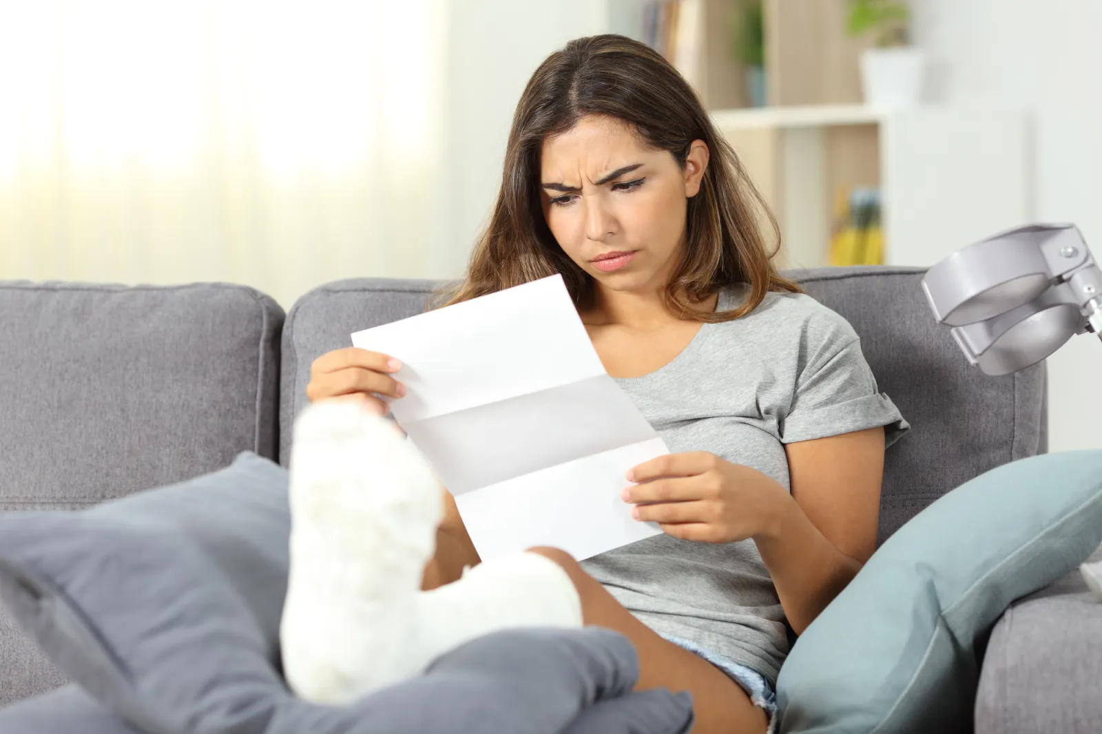 A woman looks concerned as she goes through her medical bills.