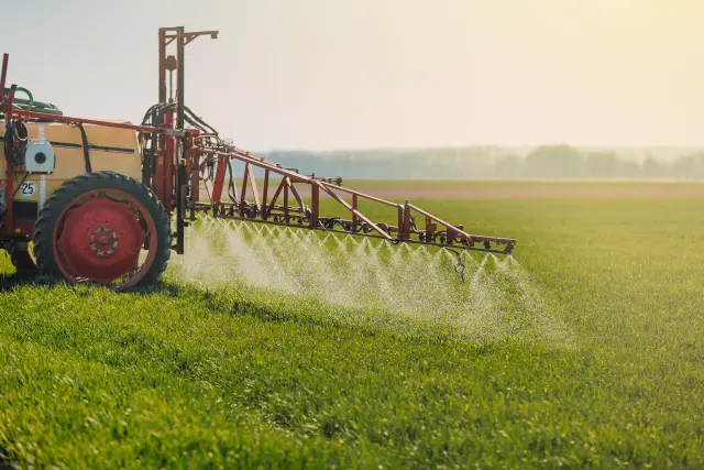 A machine sprays pesticides on a crop field.