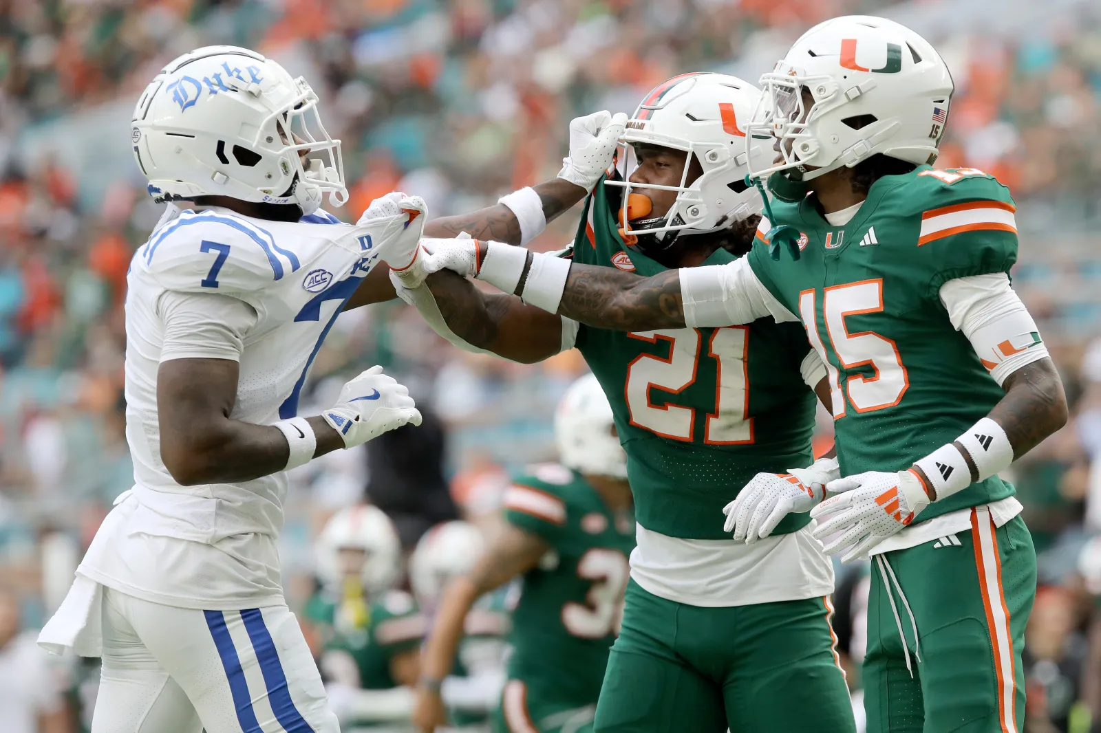 Duke Blue Devils tussle against Jaylin Alderman #21 and Markeith Williams #15 of the Miami Hurricanes