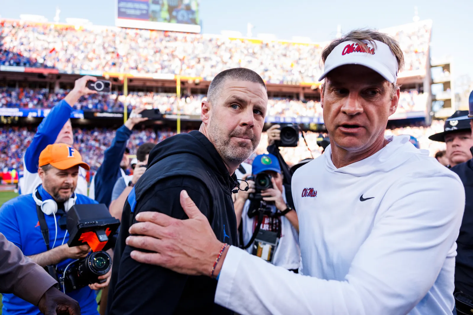 College football head coach Billy Napier of the Florida Gators (L) right shakes hands with Head coach Lane Kiffin of the Ole Miss Rebels
