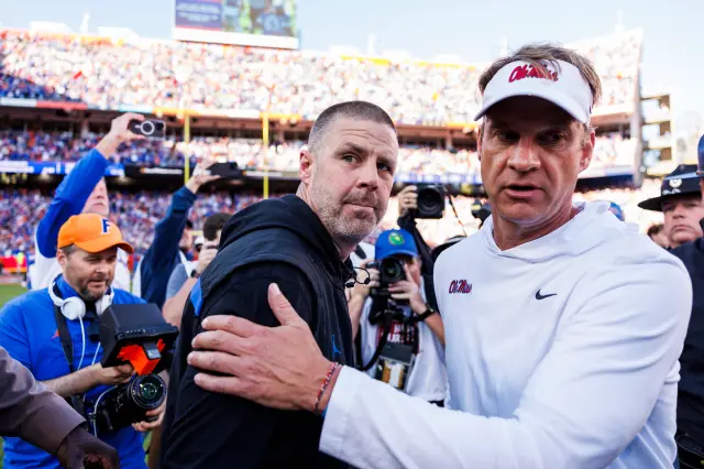 College football head coach Billy Napier of the Florida Gators (L) right shakes hands with Head coach Lane Kiffin of the Ole Miss Rebels