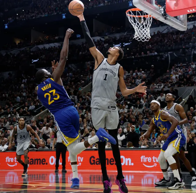Victor Wembanyama of the Spurs rejects the Warriors' Draymond Green.