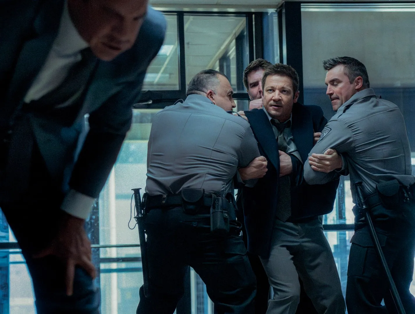 A group of men hold back a man