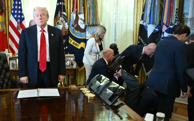President Donald Trump looks on.