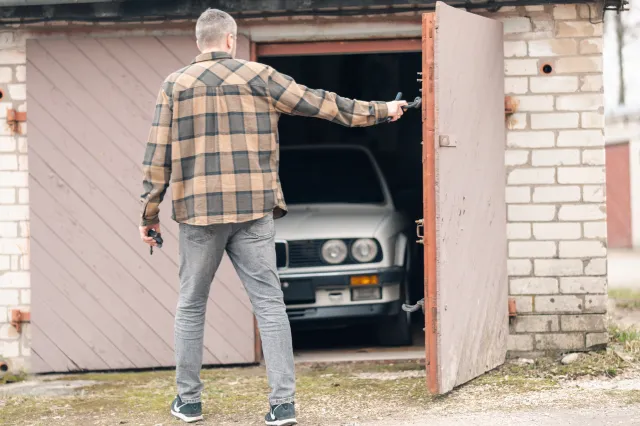 A man opening the door of his car garage.