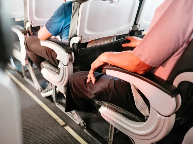 A close-up view of seats on passengers seated on a plane.
