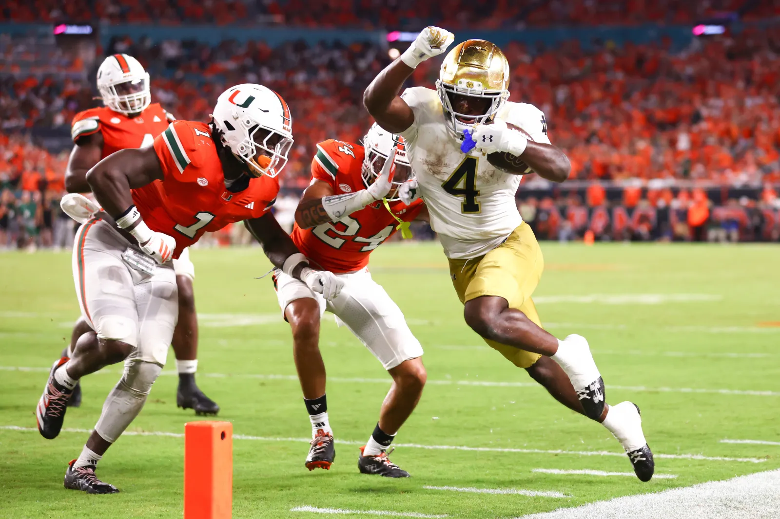 Jeremiyah Love #4 of the Notre Dame Fighting Irish carries the ball against the Miami Hurricanes