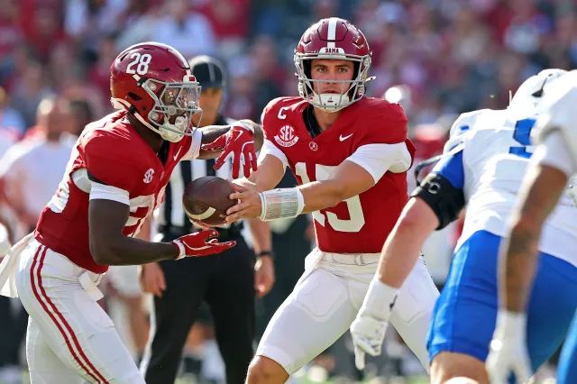 Ty Simpson #15 of the Alabama Crimson Tide hands the ball off to Kevin Riley