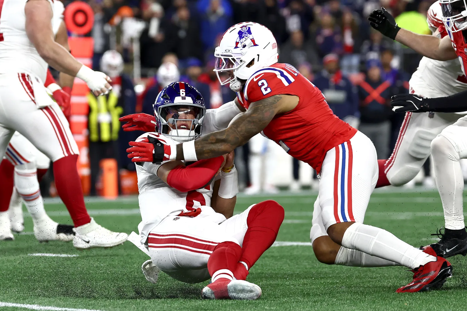Giants quarterback Jaxson Dart tackled by Patriots defender Harold Landry III