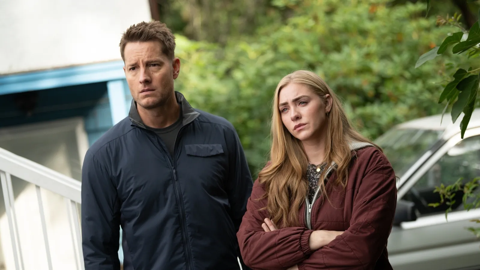 A man and a woman stand side by side outside.