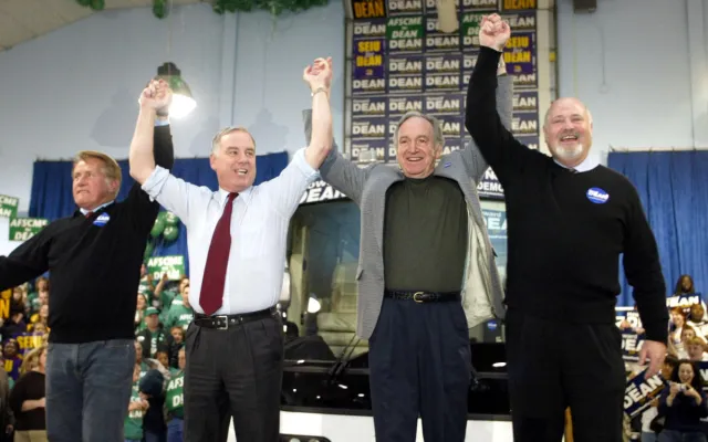 Democratic Presidential candidate Governor Howard Dean holds up the arms of actor Martin Sheen (L) Rob Reiner (R) and Iowa Senator Tom harkin (2nd R) as he kick off his "People Powered Road Trip: America at the Wheel" of Iowa 14 January 2004 during a rally at the Iowa State Fairgrounds in Des Moines, Iowa. Dean will go on a five-day multi city bus tour as he canvasses the state to rally support for the Iowa Caucus which will take place 19 January 2004. AFP PHOTO Timothy A. Clary (Photo by Timothy A. CLARY / AFP)