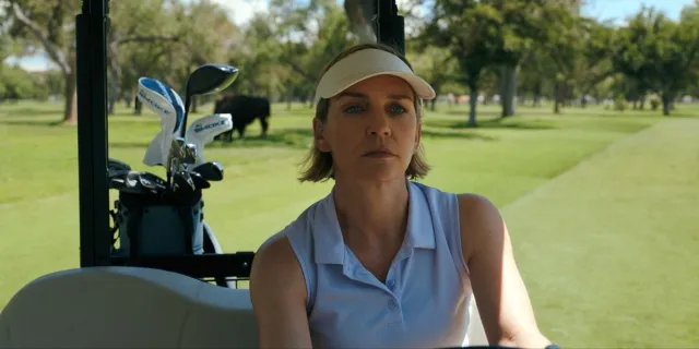 A woman drives a golf cart.