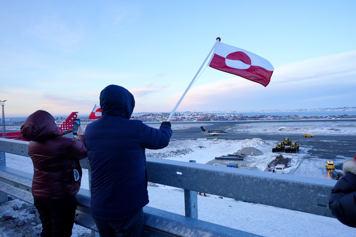 People wave the flag of Greenland as Danish Prime Minister Mette Frederiksen arrives in Nuuk, Greenland. Picture date: Friday January 23, 2026. 
