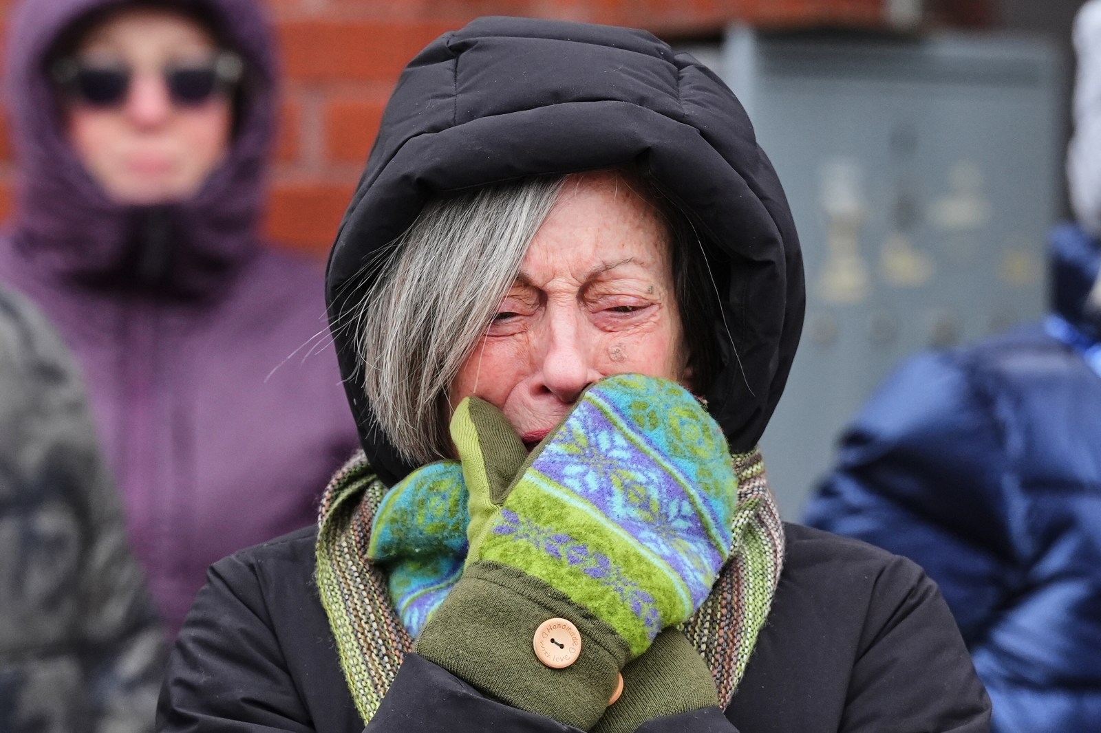 A woman is emotional while visiting a makeshift memorial for 37-year-old Alex Pretti, who was fatally shot by a U.S. Border Patrol officer over the weekend, Monday, Jan. 26, 2026, in Minneapolis. (AP Photo/Adam Gray)
