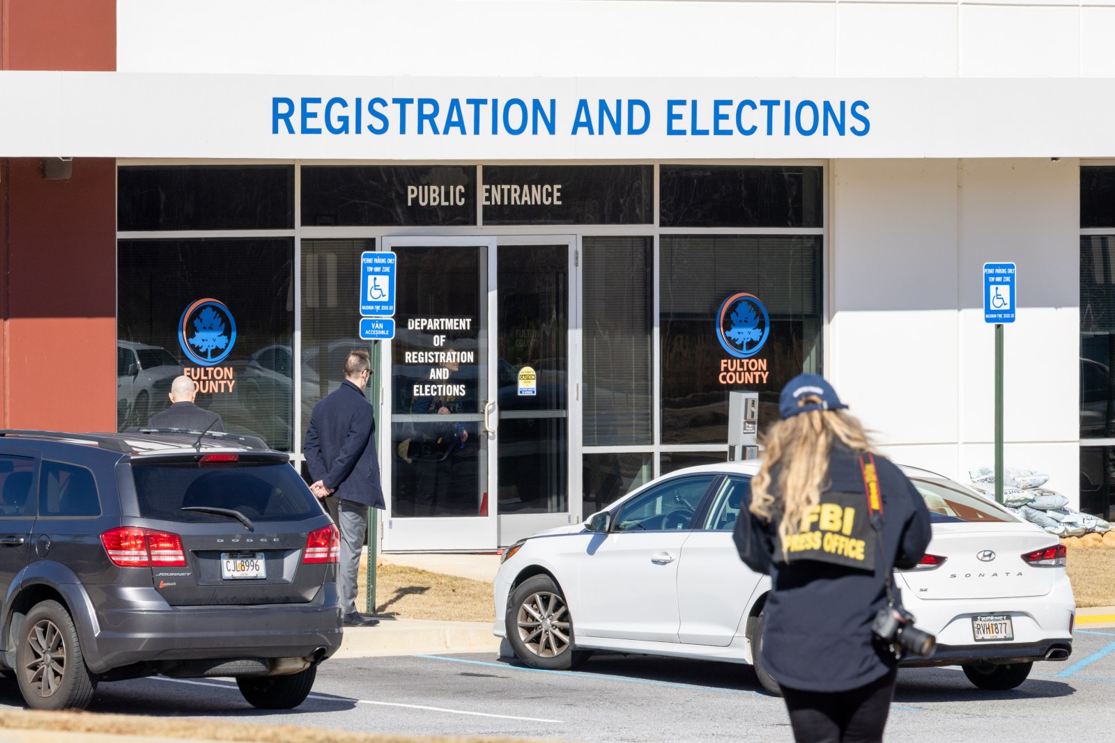 An FBI press office person approaches the Fulton County Election Hub and Operation Center, Wednesday, Jan. 28, 2026, in Union City, Ga. (Arvin Temka/Atlanta Journal-Constitution via AP)

