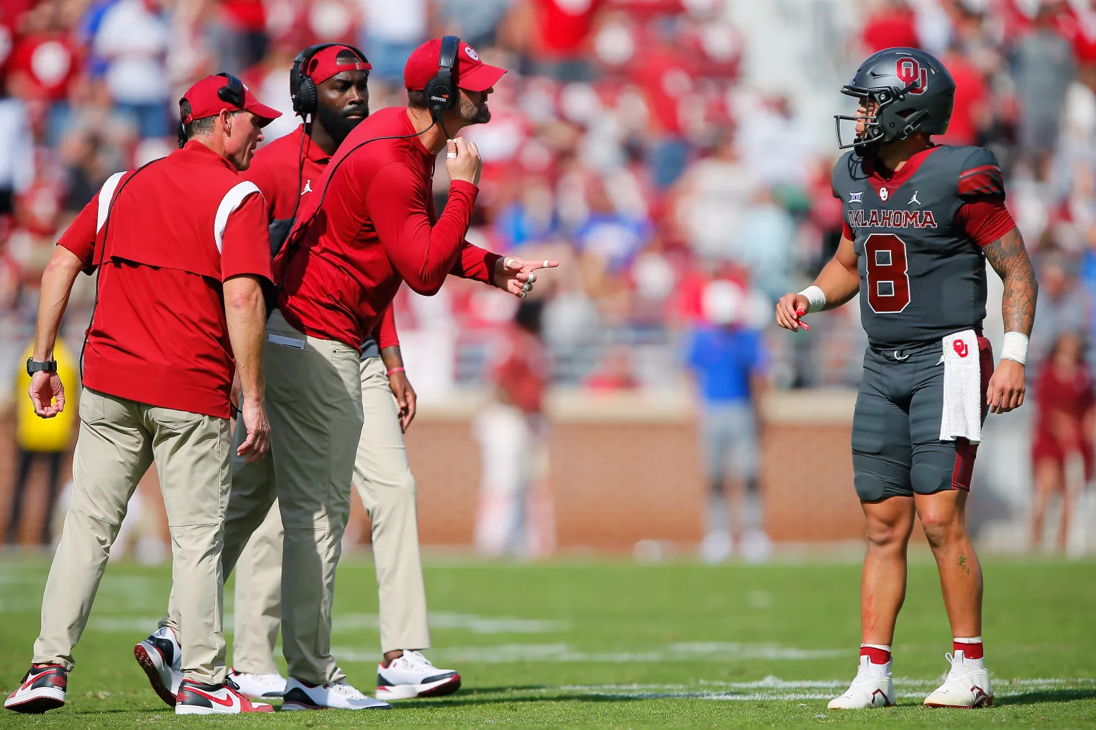 Head coach Brent Venables and running backs coach L'Damian Washington listen as tight ends coach Joe Jon Finley