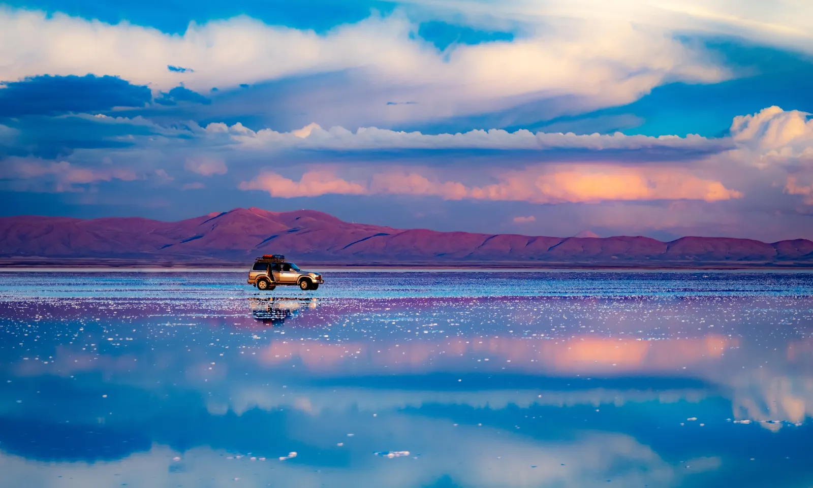 Car shown in the middle of the Salar de Uyuni salt flat in Bolivia
