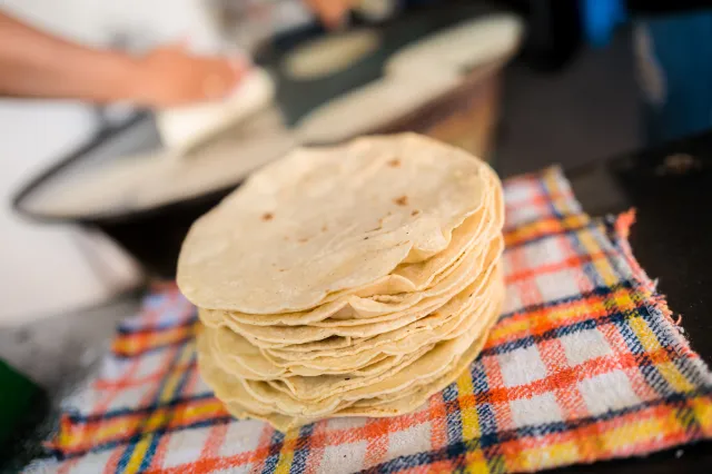 A pile of freshly made tortillas is seen placed on a cloth in a tortillería on November 5, 2022 in Morelia, Mexico