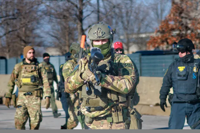 Federal agents advance during an enforcement operation outside the Whipple Building, an ICE facility, in Minneapolis, Minnesota, on January 11, 2026.
