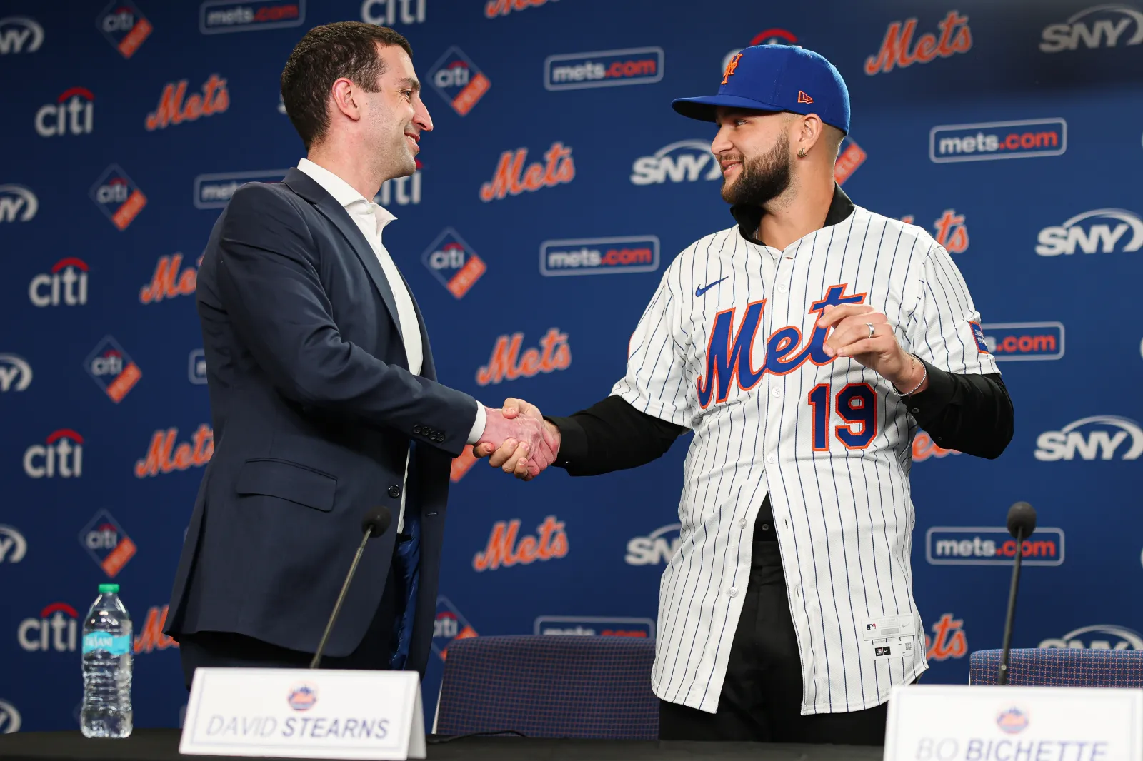 NEW YORK, NEW YORK - JANUARY 21: President of Operations David Stearns and Bo Bichette #19 of the New York Mets shake hands during an introductory press conference after signing a contract with the New York Mets at Citi Field on January 21, 2026 in the Queens borough of New York City. (Photo by Ishika Samant/Getty Images)