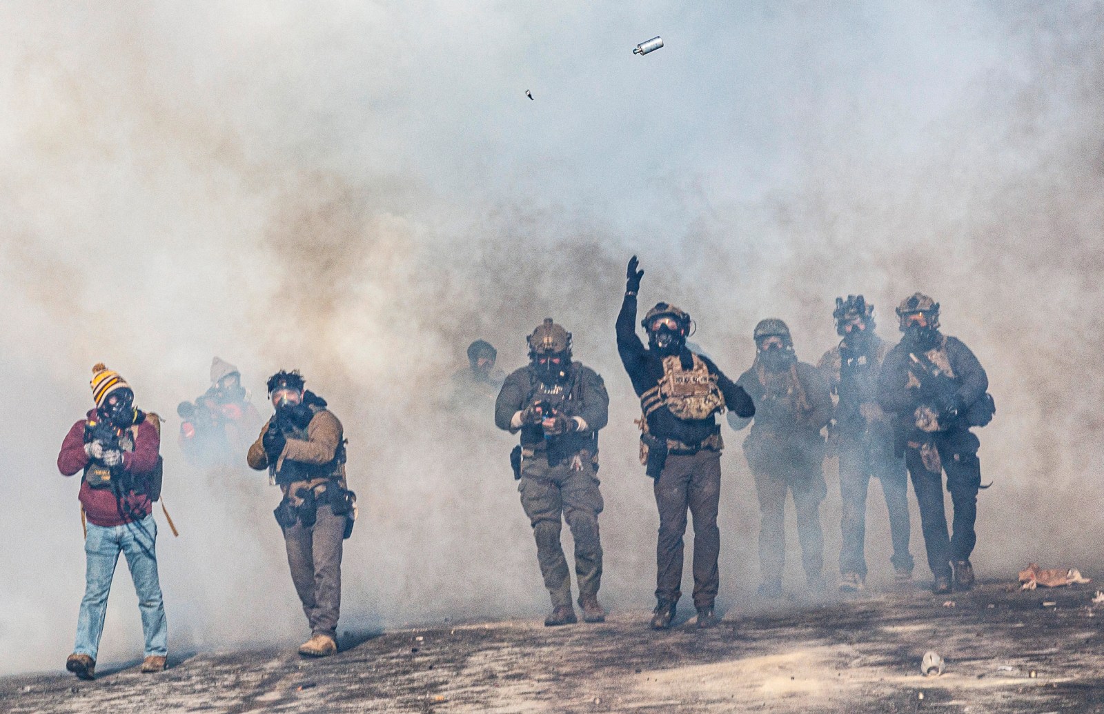 TOPSHOT – A federal agent lobs a teargas canister towards protesters as agents advance through clouds of tear gas during clashes following the fatal shooting of a protester earlier in the day, on January 24, 2026 in Minneapolis, Minnesota. Federal immigration agents shot dead a man in Minneapolis on Saturday, officials said — the second fatal shooting of a civilian in the city, sparking fresh protests and outrage from state officials. The death came less than three weeks after US citizen Renee Good was shot and killed by an Immigration and Customs Enforcement officer involved in sweeps to round up undocumented migrants. (Photo by Kerem YUCEL / AFP via Getty Images)
