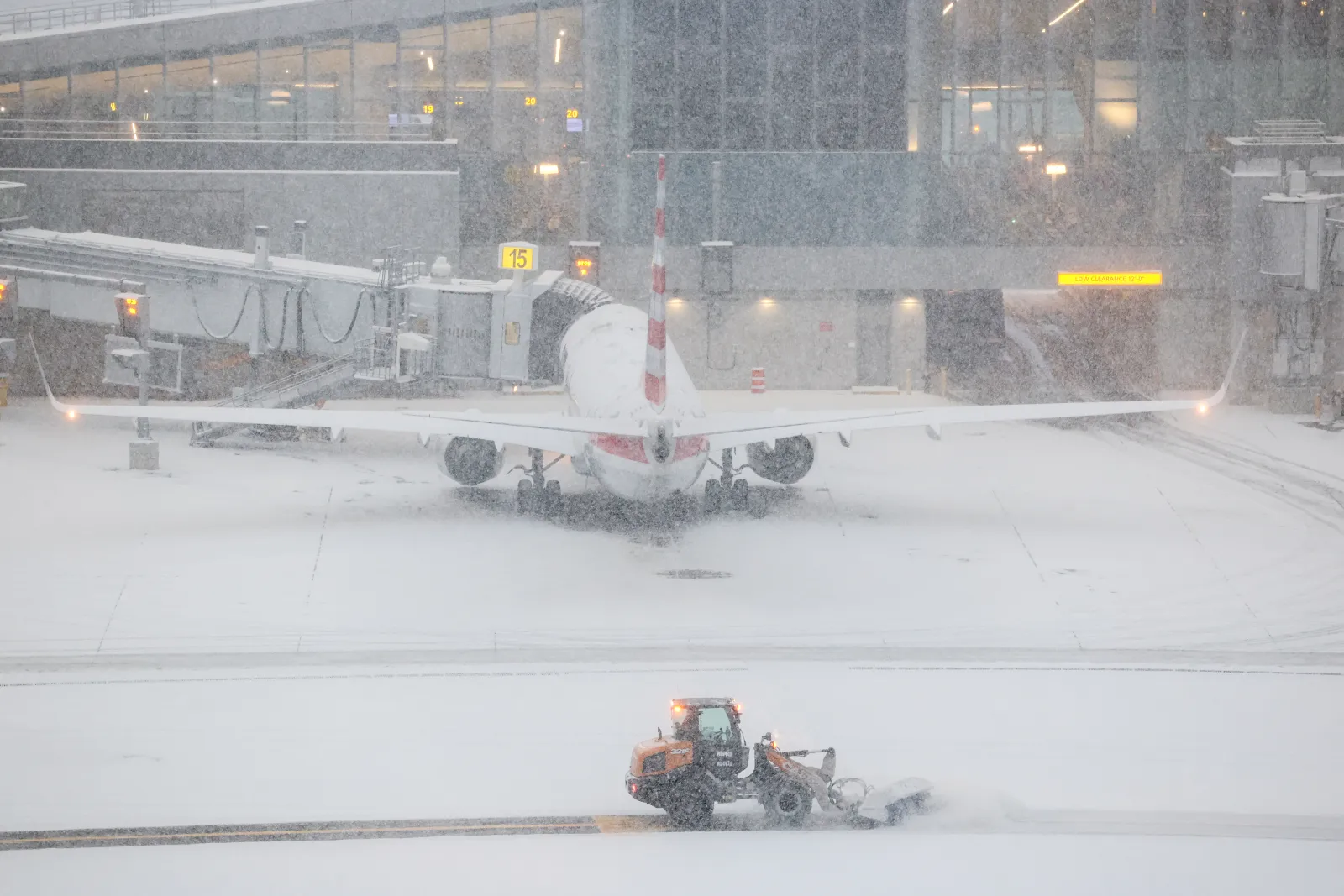 A snow removal machine is seen working on the tarmac of LaGuardia airport in New York on January 25, 2026