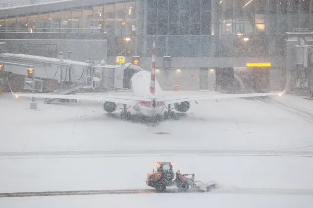 A snow removal machine is seen working on the tarmac of LaGuardia airport in New York on January 25, 2026