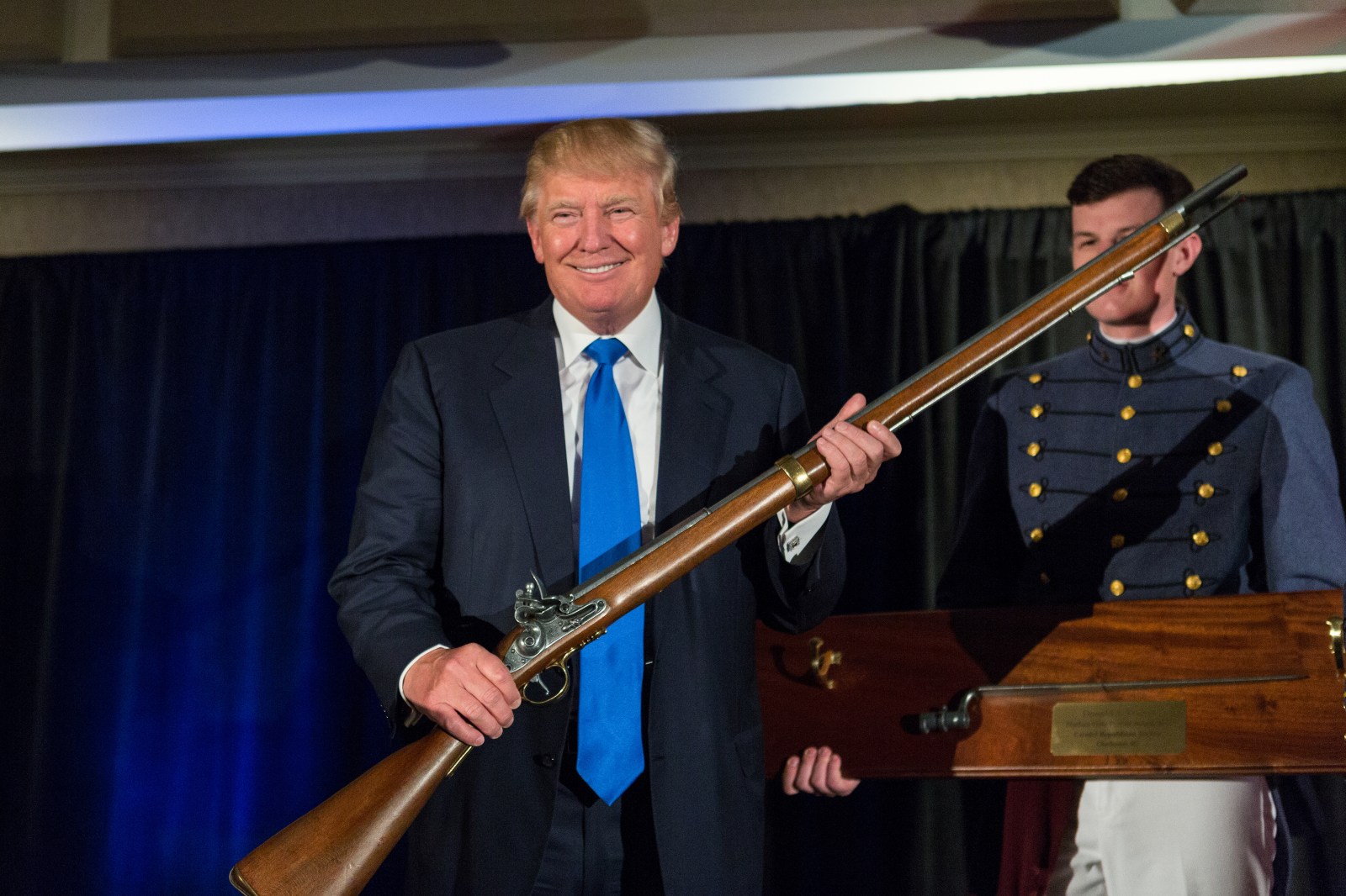 Donald Trump holds up a replica flintlock rifle awarded him by cadets during the Republican Society Patriot Dinner at the Citadel Military College on February 22, 2015 in Charleston, South Carolina. (Photo by Richard Ellis/Getty Images)
