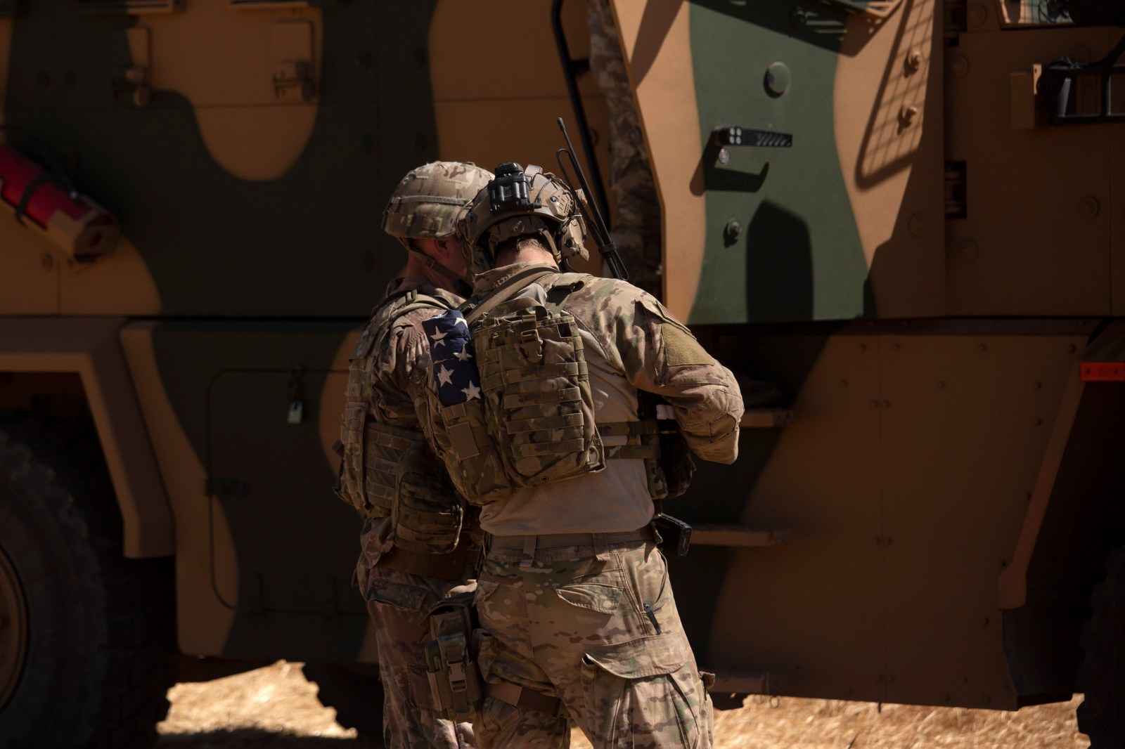 In this Sept. 8, 2019, photo, U.S. soldiers stand near a Turkish armored vehicle during the first American-Turkish joint patrol in the so-called “safe zone” on the Syrian side of the border with Turkey near Tal Abyad, Syria. (AP Photo/Maya Alleruzzo)