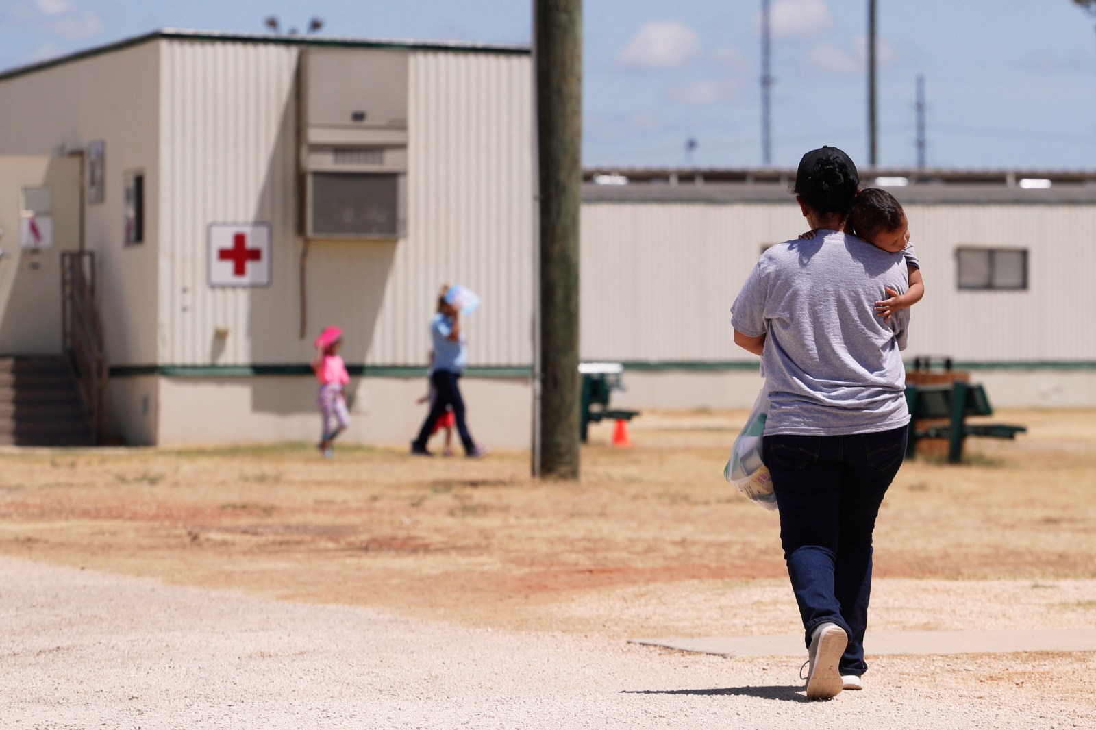 FILE – Immigrants seeking asylum walk through the ICE South Texas Family Residential Center in Dilley, Texas, on Aug. 23, 2019. (AP Photo/Eric Gay, File)