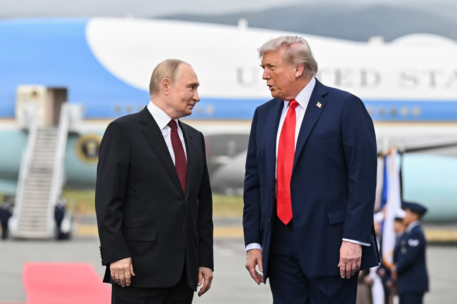 Russian President Vladimir Putin and U.S. President Donald Trump pose on a podium on the tarmac after they arrived to attend a meeting at Joint Base Elmendorf-R