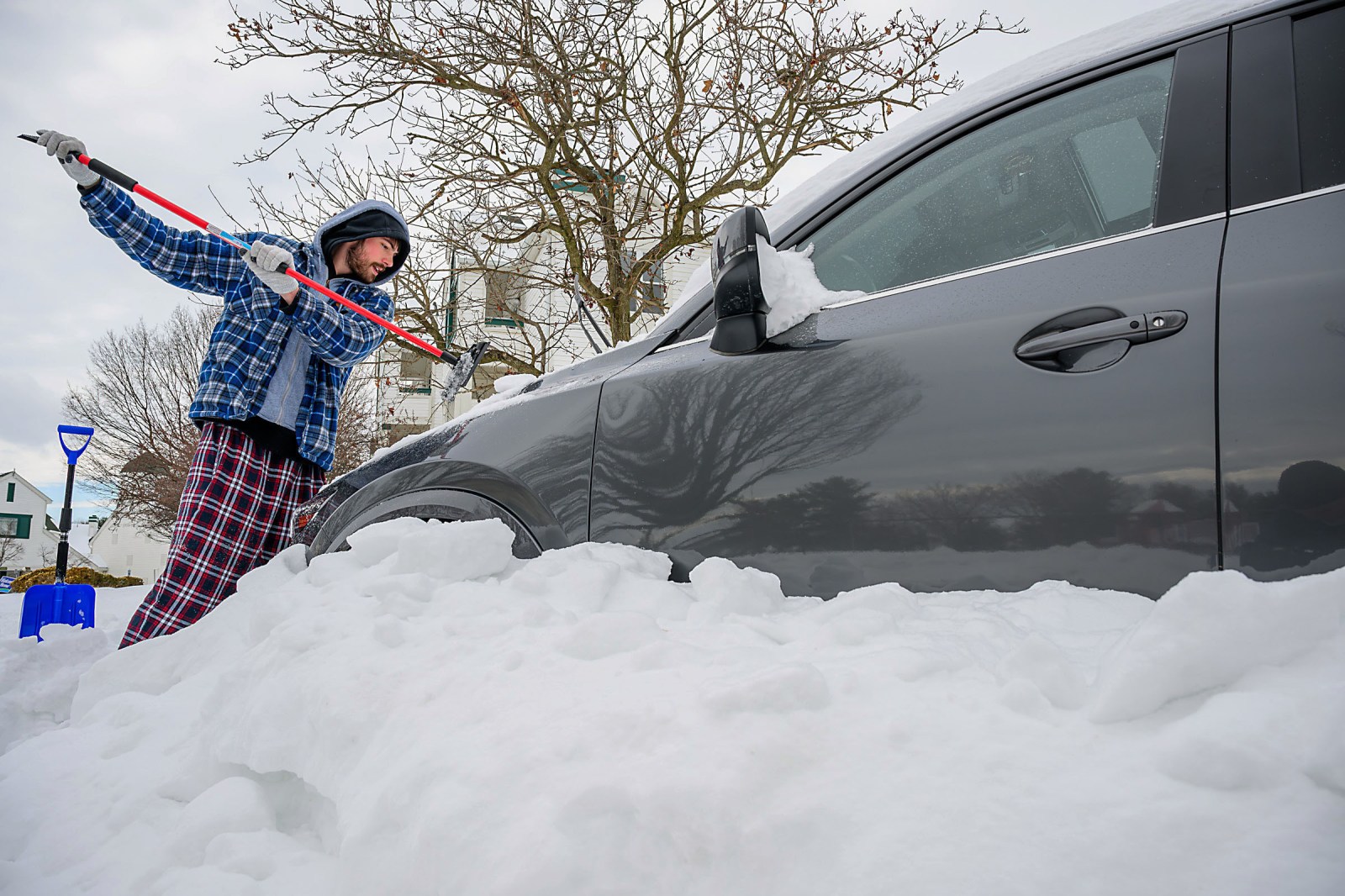 Soren Almquist clears the snow off his girlfriend’s car along Fairview Avenue in Frederick, Md. on Monday, Jan. 26, 2026. (Ric Dugan/The Frederick News-Post via AP)