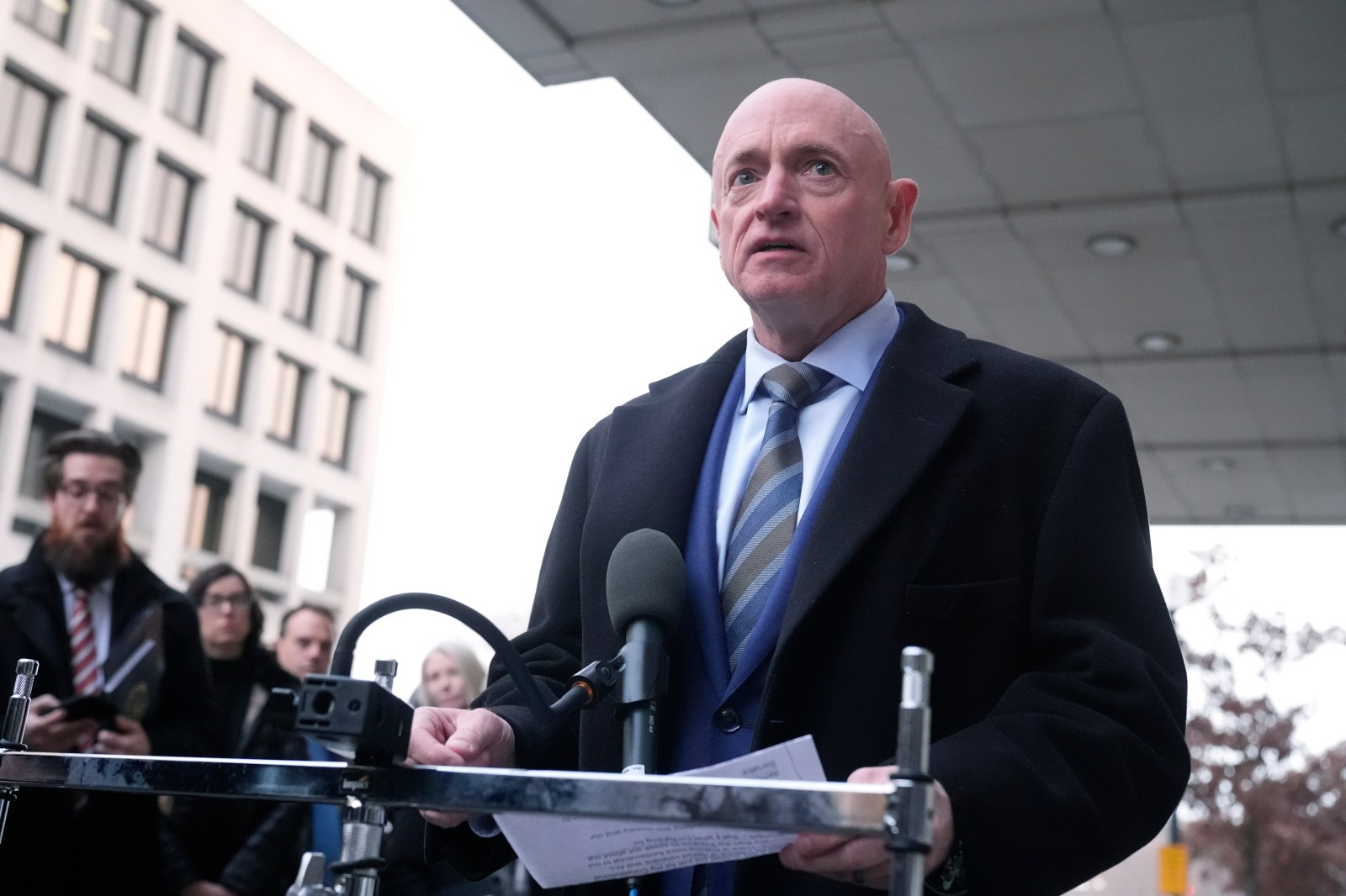 Sen. Mark Kelly, D-Ariz.,speaks to reporters outside of federal court in Washington, Tuesday, Feb. 3, 2026. (AP Photo/Mark Schiefelbein)
