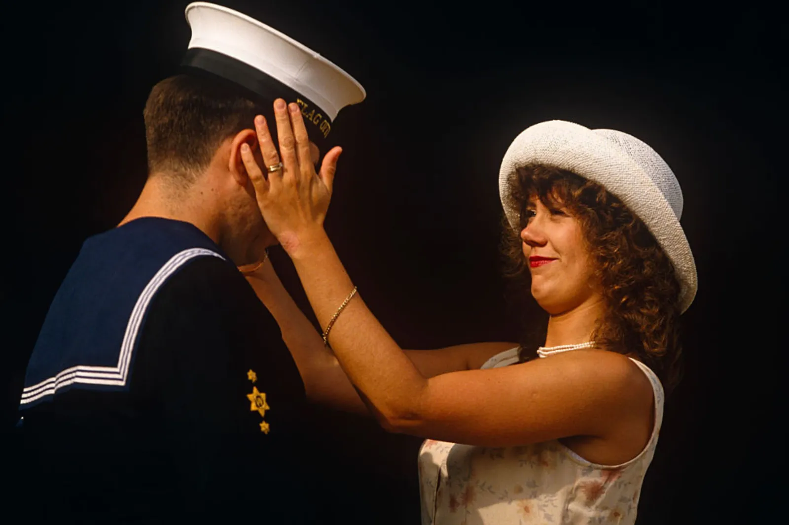 A woman with her hands on the face of her sailor husband ahead of a Buckingham Palace garden party in after sunshine in London in the United Kingdom.