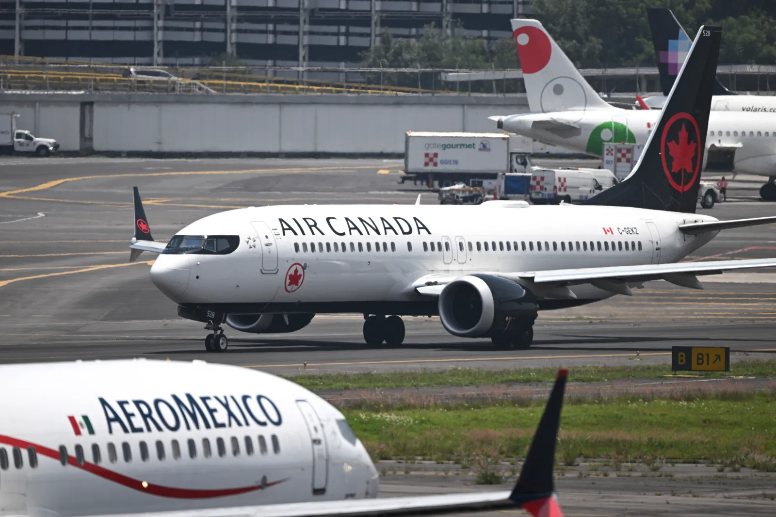 A plane of Canada's airline Air Canada taxi next to Mexico's airline Aeromexico at Benito Juarez International Airport in Mexico City on July 22, 2025.