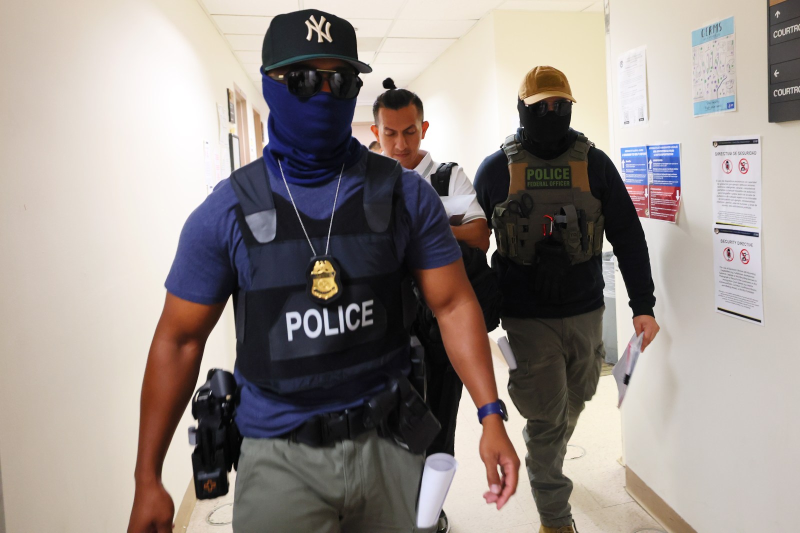 Federal agents detain a person exiting a court hearing at immigration court at the Jacob K. Javits Federal Building on August 06, 2025 in New York City. 
