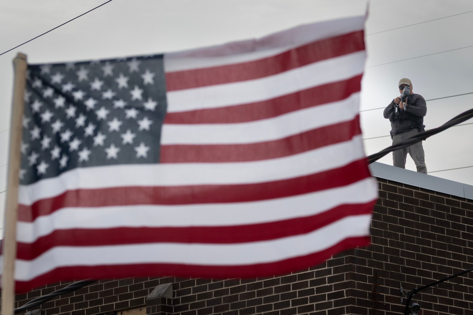 A federal law enforcement agent aims a pepper ball gun at demonstrators protesting outside of an immigration processing center on September 19, 2025 in Broadview, Illinois.