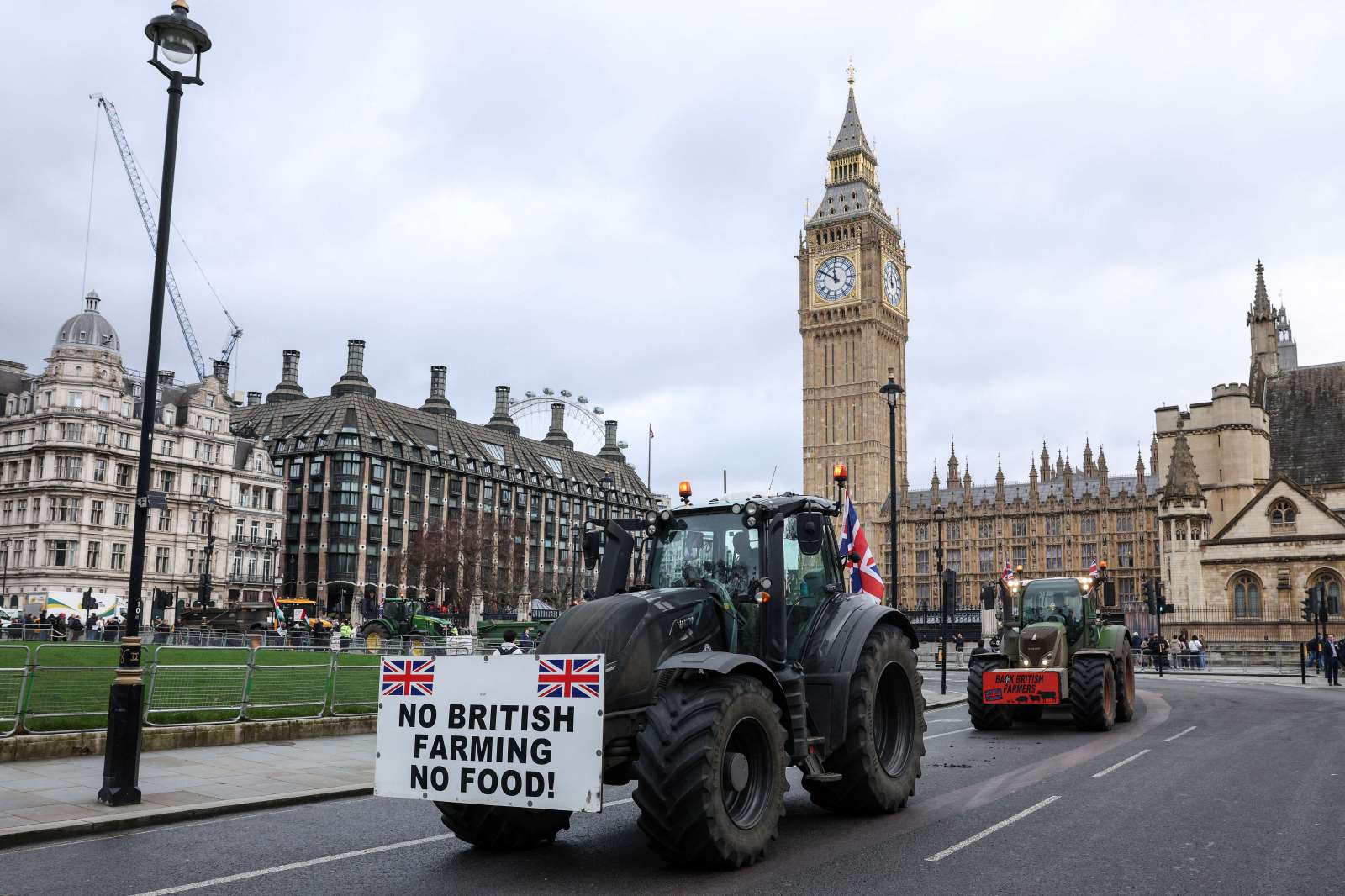 TOPSHOT – Farm tractors decorated with placards to support British farmers and to protest against Britain’s Prime Minister Keir Starmer, drive through the streets by Parliament Square in central London on February 11, 2026. (Photo by Adrian DENNIS / AFP via Getty Images)