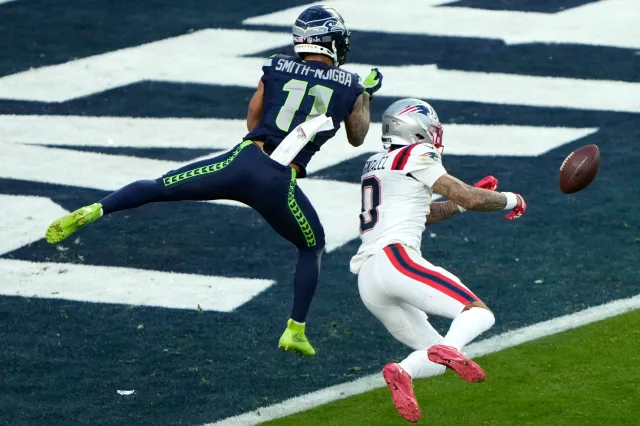 Christian Gonzalez #0 of the New England Patriots breaks up a pass intended for Jaxon Smith-Njigba #11 of the Seattle Seahawks