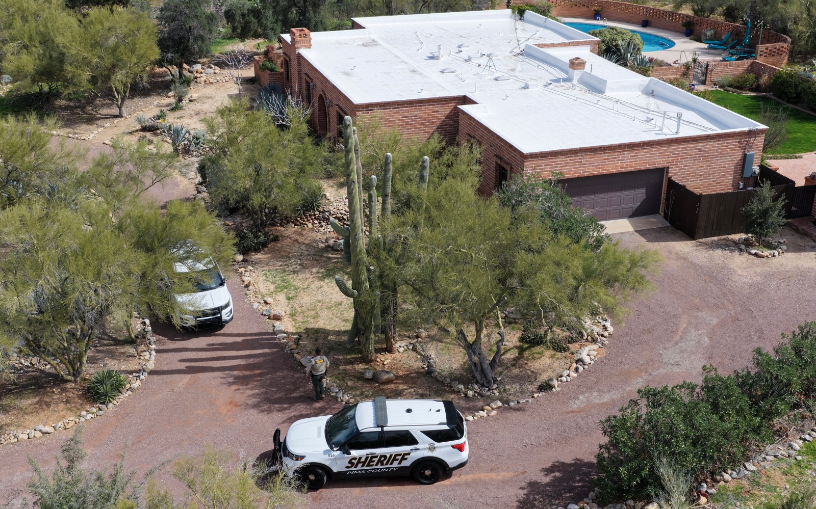 In an aerial view, Pima County Sheriff’s vehicles sit in the driveway of the home of Nancy Guthrie on February 20, 2026, in Tucson, Arizona. Law enforcement officials continue to search for Nancy Guthrie, the 84-year-old mother of U.S. journalist and television host Savannah Guthrie, after she went missing from her home on the morning of February 1. (Photo by Joe Raedle/Getty Images)